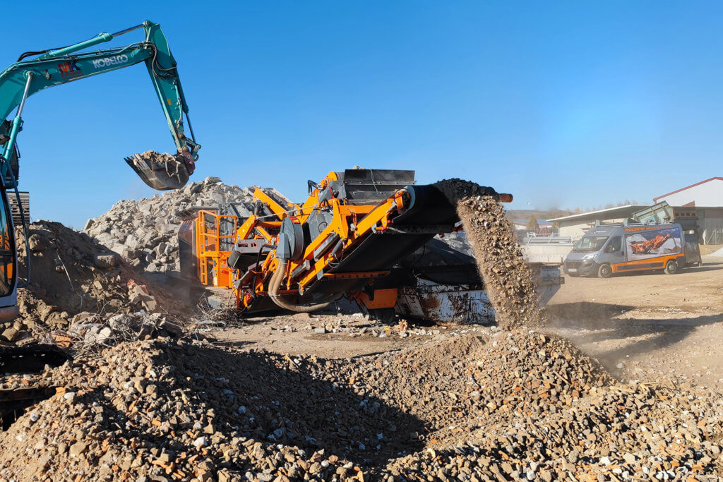 Mobile compact crusher recycling construction and demolition waste and a recycling center with the blue sky